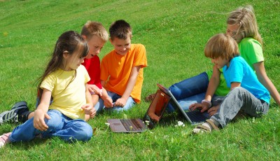 Children outdoors with laptops